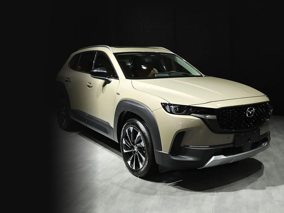 2023 Mazda CX-50 Hybrid compact SUV in a dark showroom, front three-quarter view