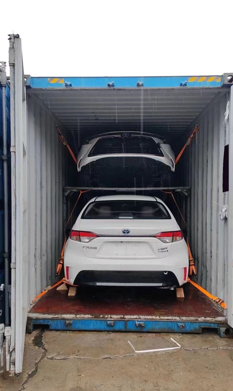 Two cars loaded on a container rack